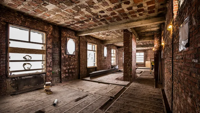 Room featuring exposed brick and wood plank flooring during renovation