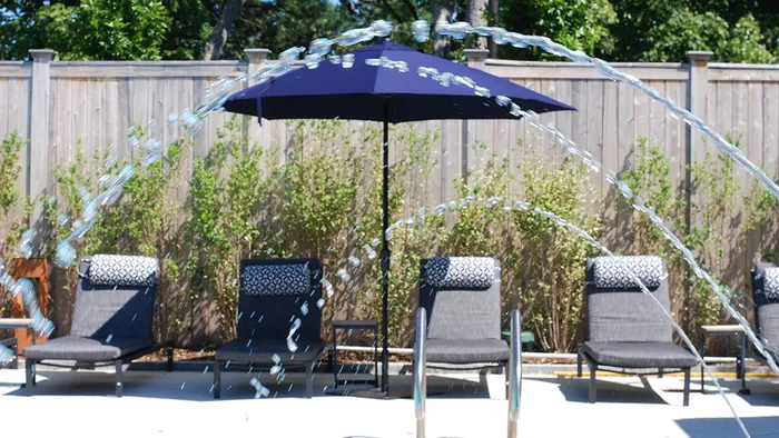 Pool-Side Deck Featuring Lounge Chairs and Shade Umbrellas at Modera Needham Apartments