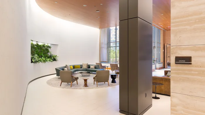 Well lit resident lounge with floor to ceiling windows and ample seating