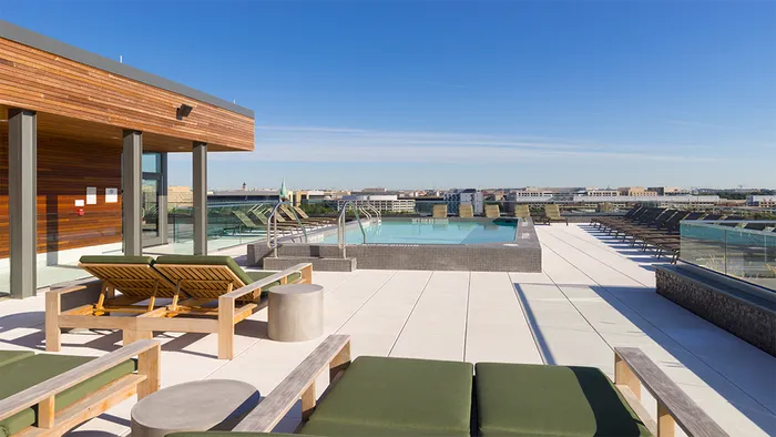 Rooftop pool with sundeck featuring chaise lounge seating