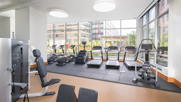 Fitness center with cardio machines overlooking a well manicured courtyard
