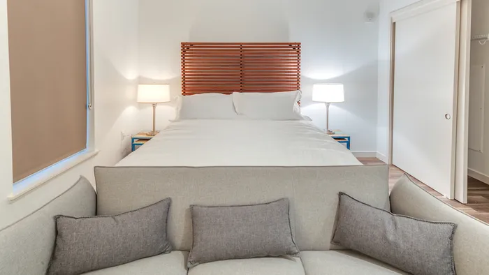 Studio Home with Bed, Nightstands, and Seating at Foot of Bed