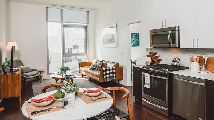 Open concept kitchen into dining and living area with floor to ceiling windows