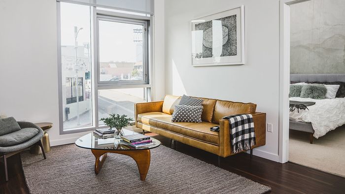 Well lit living room room peaking into bedroom
