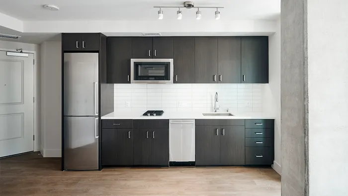 Beautiful kitchens with custom wood cabinetry, speed ovens, and stainless steel appliances in an apartment at Modera Rincon Hill.
