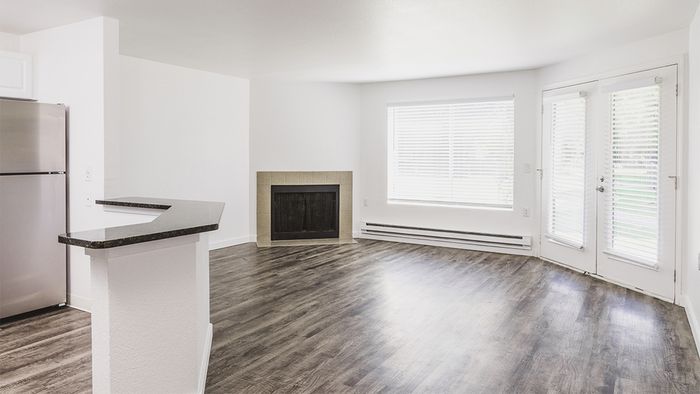 Open style floor plan featuring wood-plank style flooring, fireplace and oversized windows