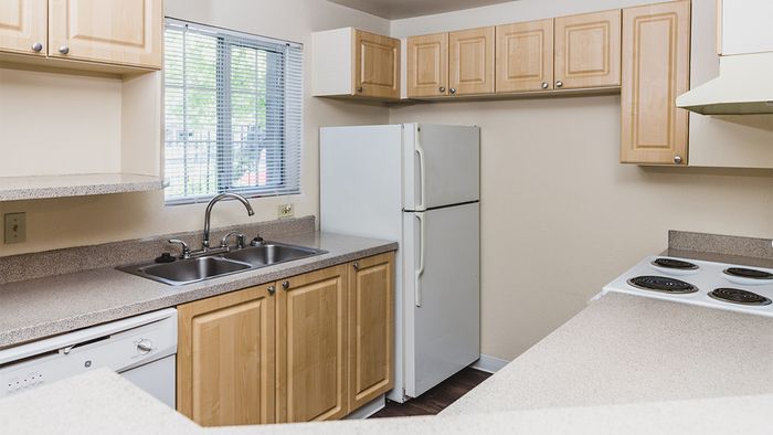 Kitchen with light oak cabinetry and white appliances