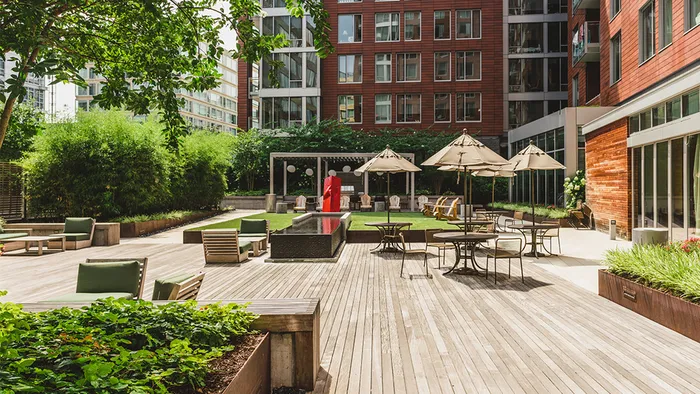 Community courtyard with green space, water feature and patio tables
