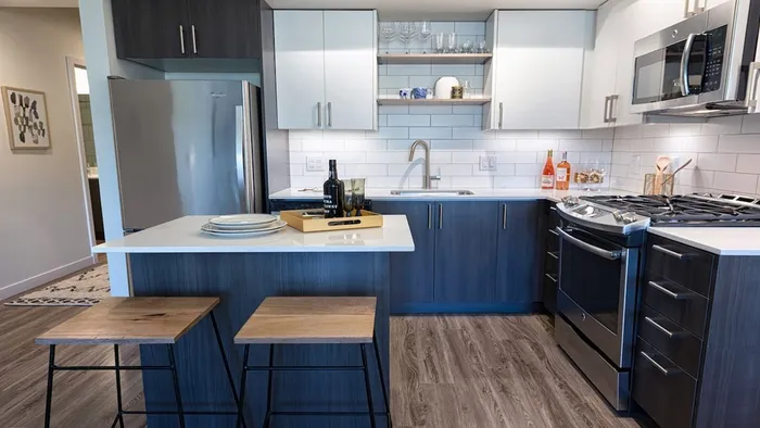 Kitchen with island, stainless appliances and bi-color cabinets