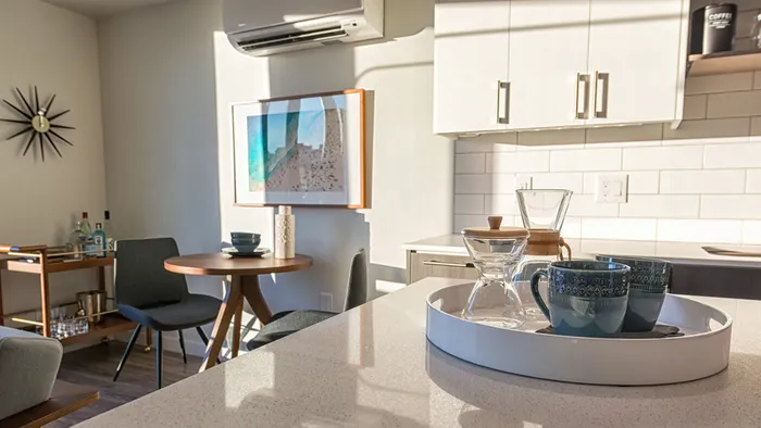 Close up of kitchen island with quartz counters and subway tile in background