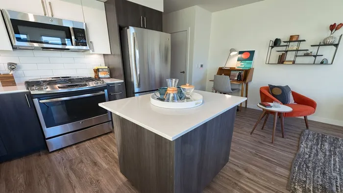 Kitchen island with quartz counters and hardwood floors in kitchen