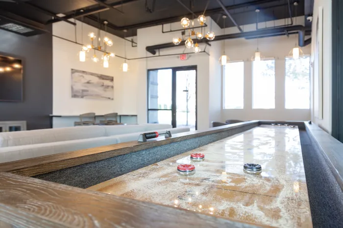 shuffle board game in lounge at Alister uptown apartments in charlotte north carolina