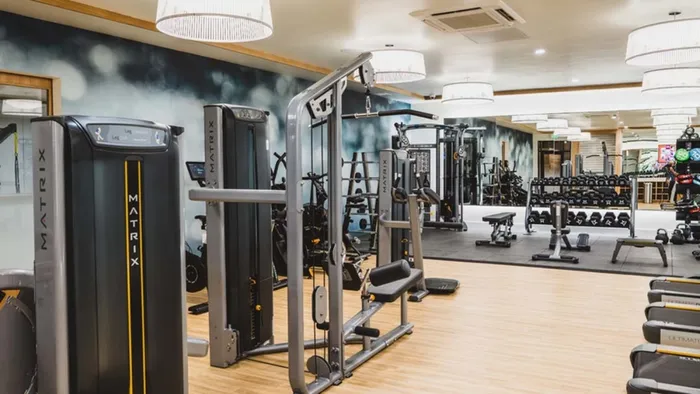 Fitness studio with exquisite lighting, mirrors, weight machines and treadmills at Modera Broadway apartments.