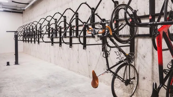 Hanging bikes on bike rack on a concrete wall at Modera Broadway apartments.