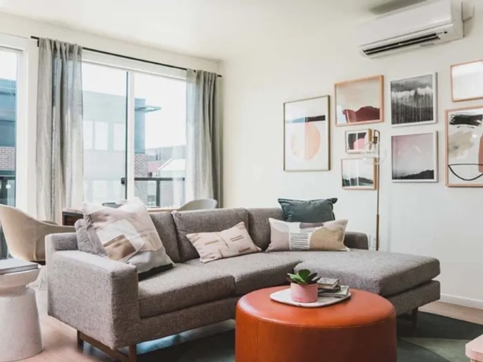 Functional living space with large floor to ceiling windows and galley kitchen at Modera Broadway apartments in Seattle.