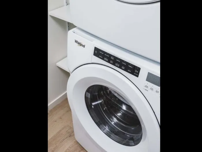 Close up of front-loading washing machine in apartment at Modera Broadway - Seattle.