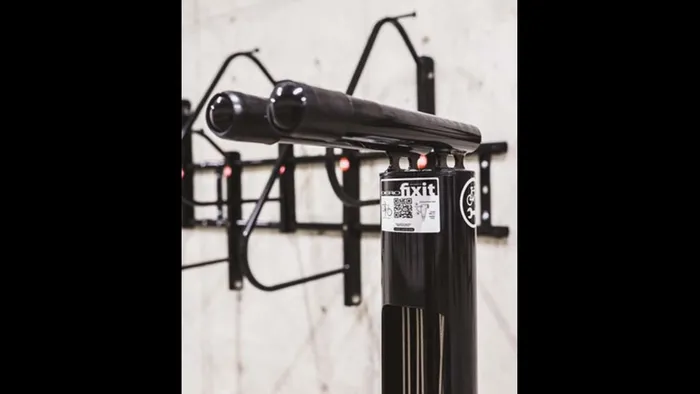 Bike fix-it station hanging on the wall in the bike storage area at Modera Broadway apartments.