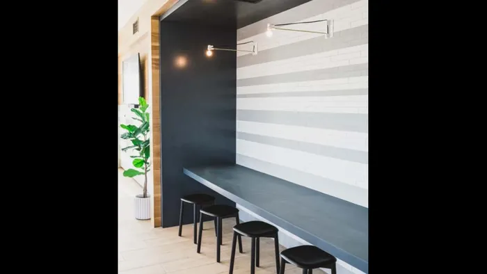 Stylish bar seating at a wall that feels like a coffee shop at Modera Broadway apartments.