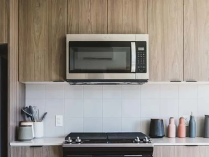 Stainless steel appliances in kitchen with white tile backsplash at Modera Broadway Apartments.