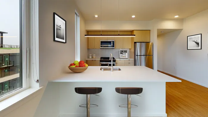 Beautiful kitchens with custom wood cabinetry and stainless steel appliances at Modera Broadway Apartments in Seattle.