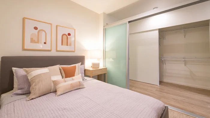 Bedroom with sliding privacy door in an apartment at Modera Broadway.
