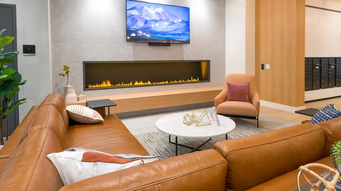 Luxurious lounge and lobby space with leather sofa and fireplace  at Modera Broadway apartments in Seattle.