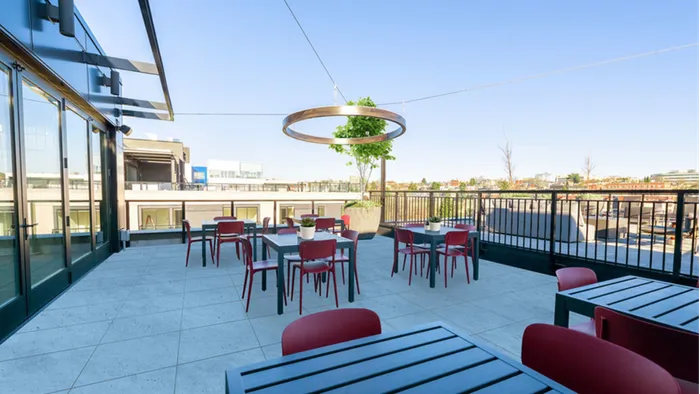 Rooftop outdoor dining tables with stylized lighting and seating at Modera Broadway apartments in Seattle.