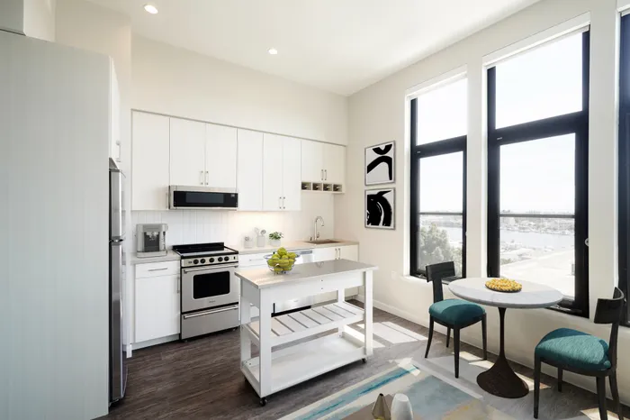 high-end kitchen and dining space with natural light at modera jack london square apartment homes for rent in oakland california