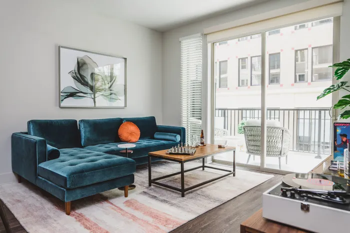 small sectional blue couch in living room looking onto balcony at modera decatur apartment homes for rent in georgia