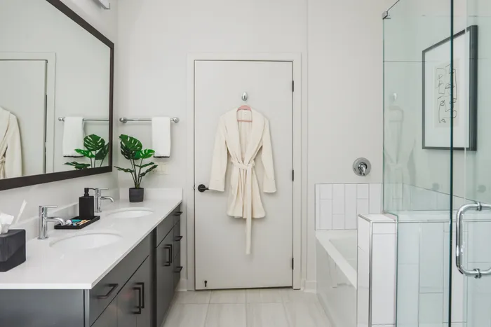 bathroom with double-vanity and glass enclosed shower at modera decatur apartment homes for rent in georgia