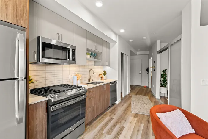 Kitchen with stainless steel appliances quartz countertops and custom cabinetry