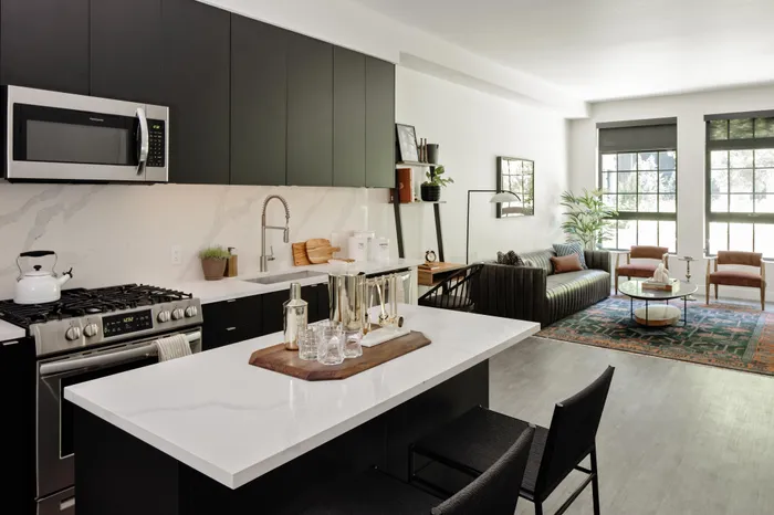 kitchen with stainless steel appliances looking into living room modera art park apartment homes for rent in denver colorado