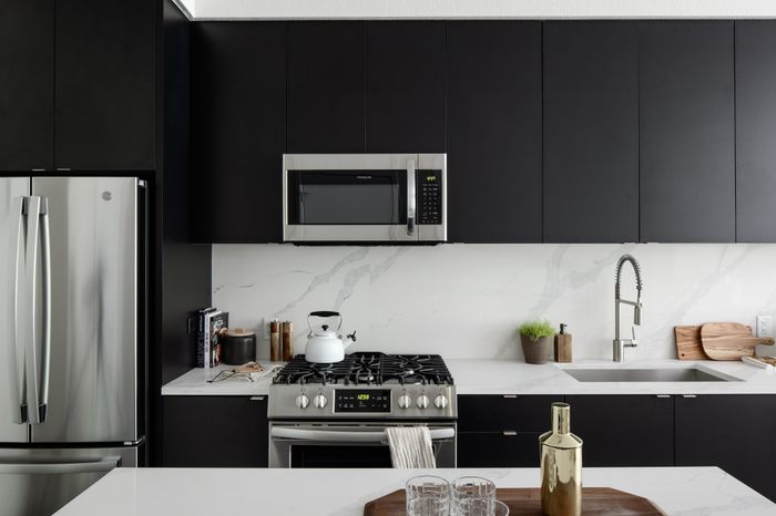 dark cabinets and quartz countertops with stainless steel appliances in kitchen modera art park apartment homes for rent in denver colorado