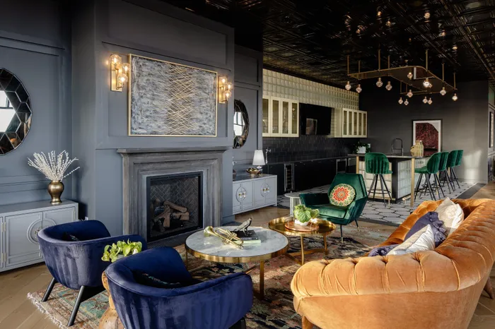 clubhouse with fireplace and seating leading into demonstration kitchen bar seating area modera art park apartment homes for rent in denver colorado