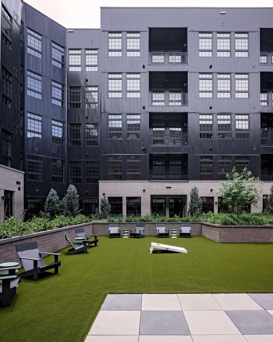outdoor courtyard with seating and cornhole game modera art park apartment homes for rent in denver colorado