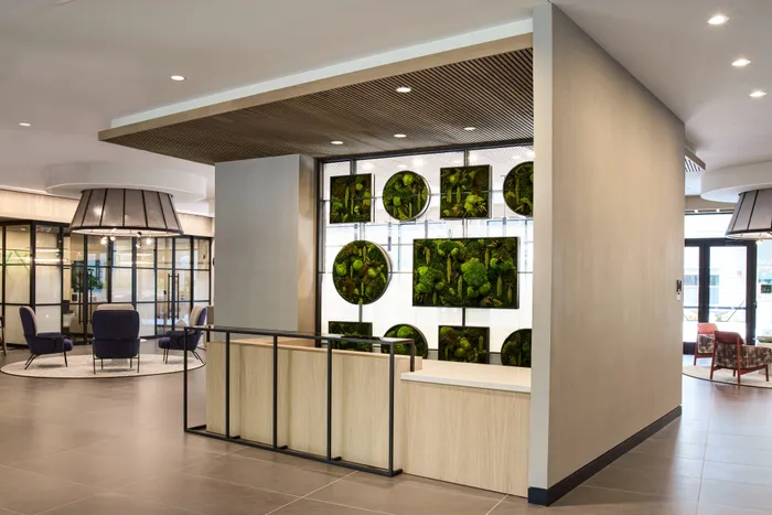front concierge desk in lobby with artwork at modera clarendon apartment homes for rent in arlington va
