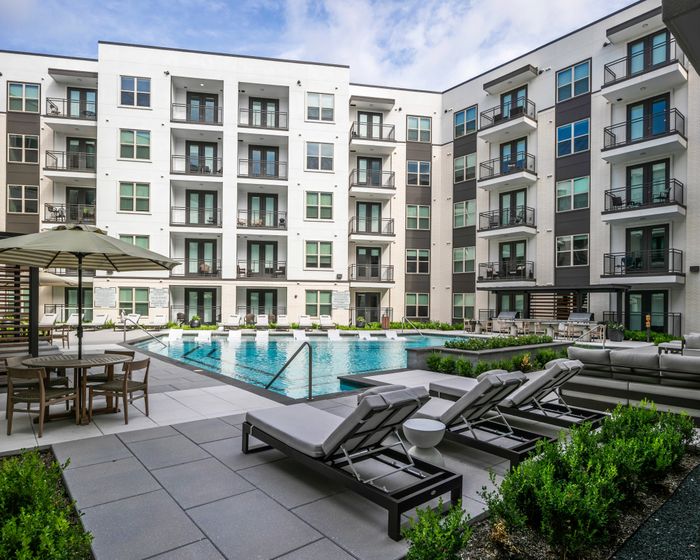 large pool with lounge seating on sundeck at modera six pines apartment homes for rent in shenandoah texas