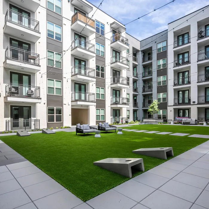 courtyard with lawn games at modera six pines apartment homes for rent in shenandoah texas