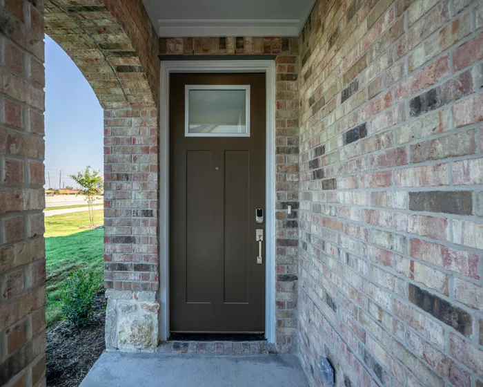 Covered entryway to brown front door with smart lock