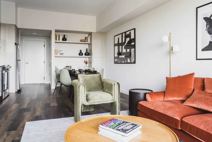 spacious living room with orange couch and hardwood style flooring