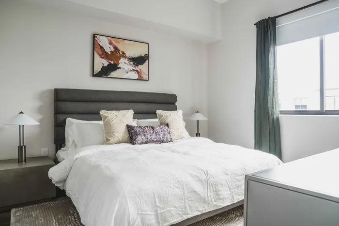 Modern bedroom with large bed and oversized windows