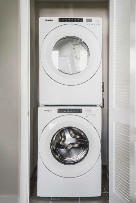 Modera Coral Springs | White, stackable front-loading washer and dryer in closet