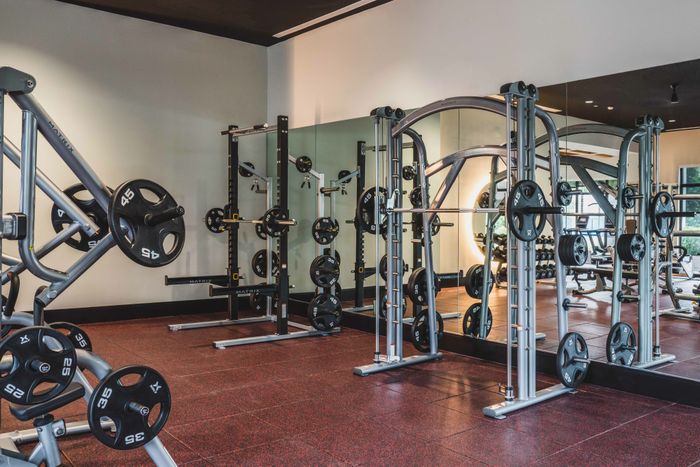 fitness center with squat racks and plenty of weights