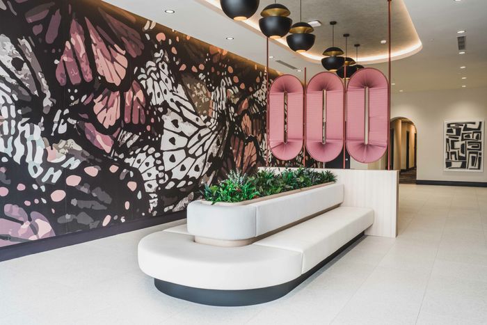 community room with large couch in the center and local artwork displayed on walls
