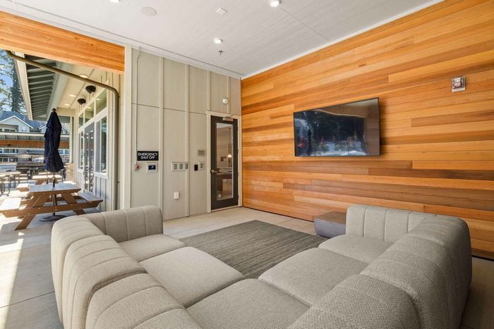 Poolside lounge area with outdoor TVs and lounge couch