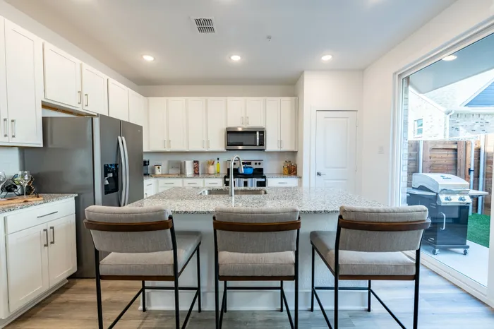 kitchen island with bar seating at amavi celina single family homes for rent in texas