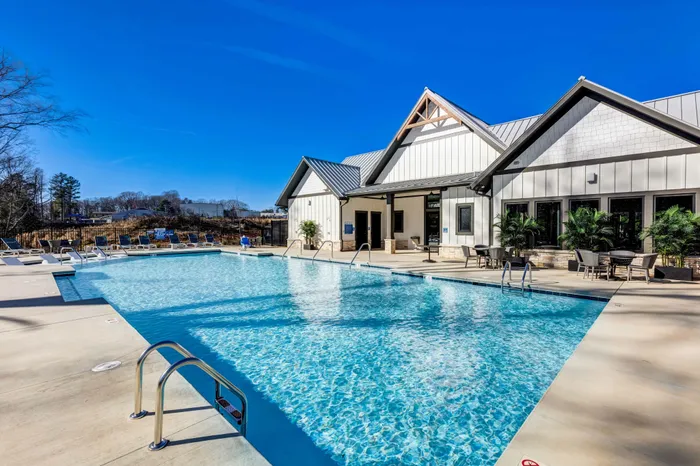 Large blue pool with white and gray clubhouse in the background