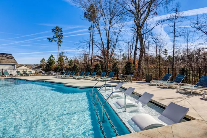 large blue pool with lounge style sundeck seating