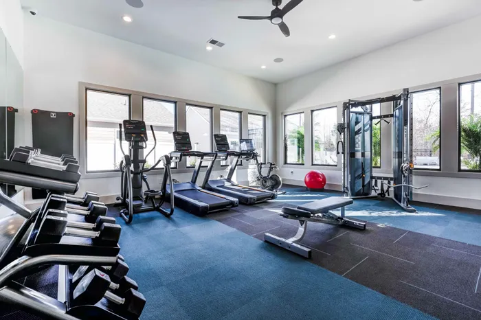 Fitness center featuring plenty of cardio equipment and more