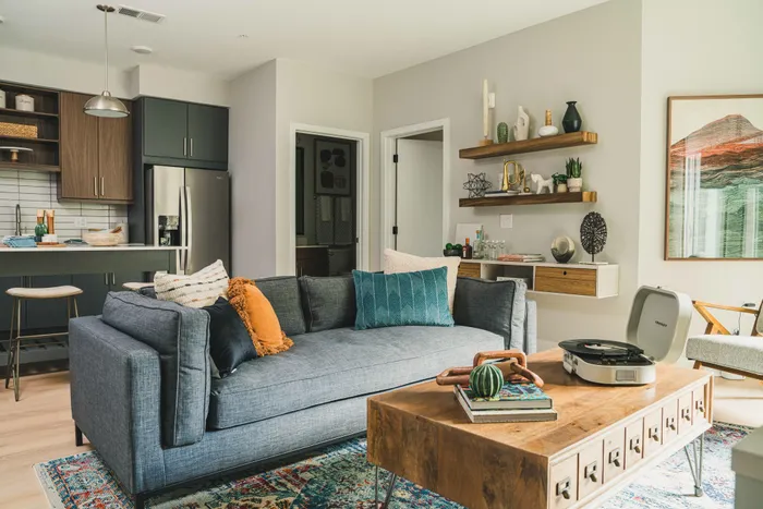 view of living room with gray couch and kitchen in the background